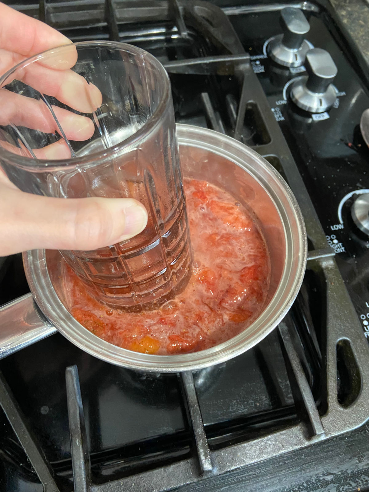 glass mashing down strawberries. 