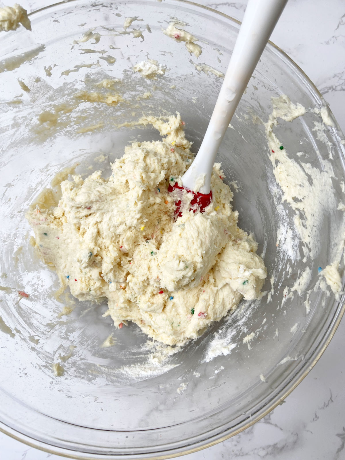 cake mixture in a clear bowl with a spatula. 