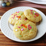 gooey Easter cookies on a white plate with a brown wooden board.