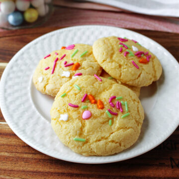 gooey Easter cookies on a white plate with a brown wooden board.