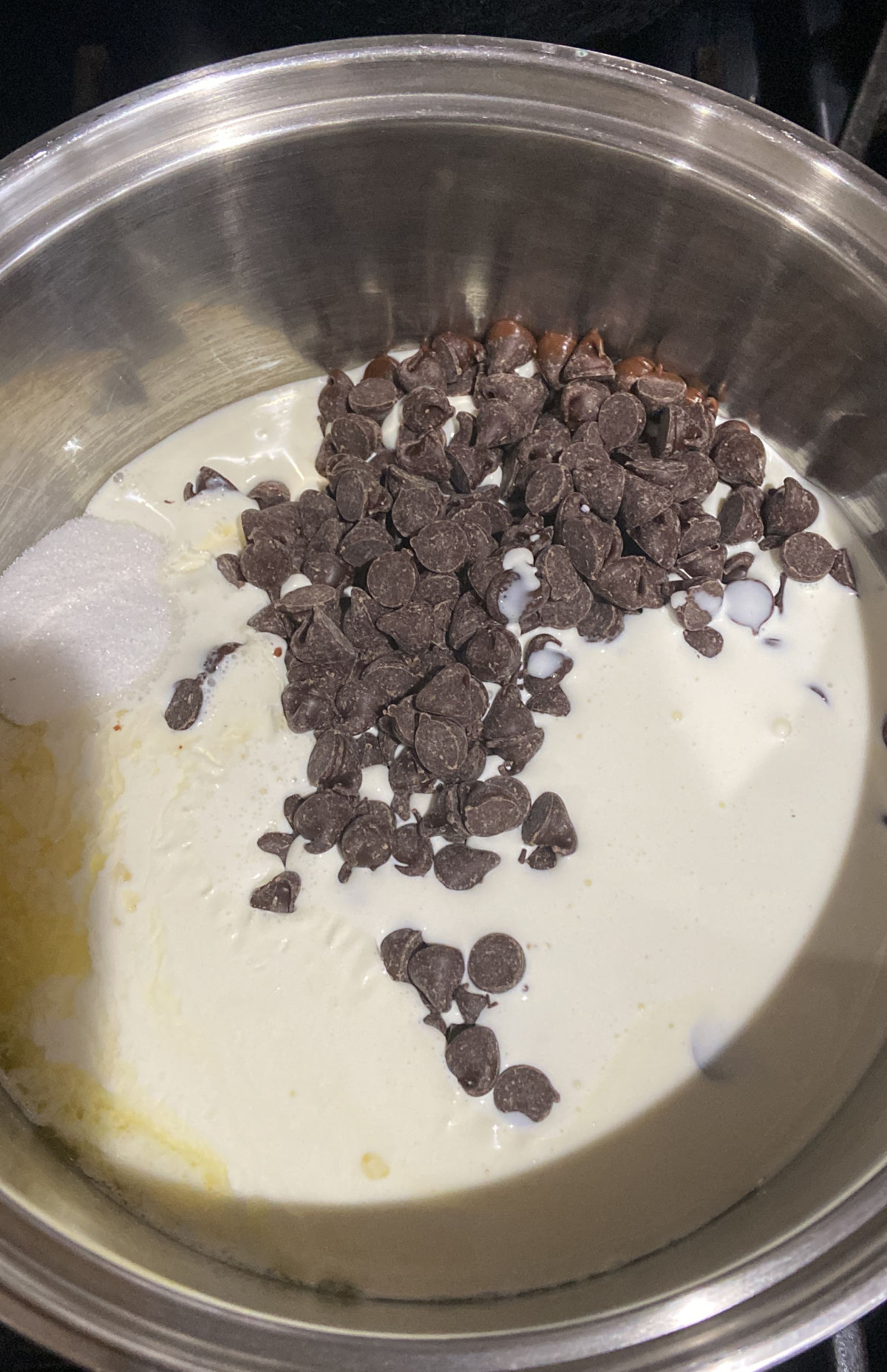 chocolate chips melting with cream in a pan. 