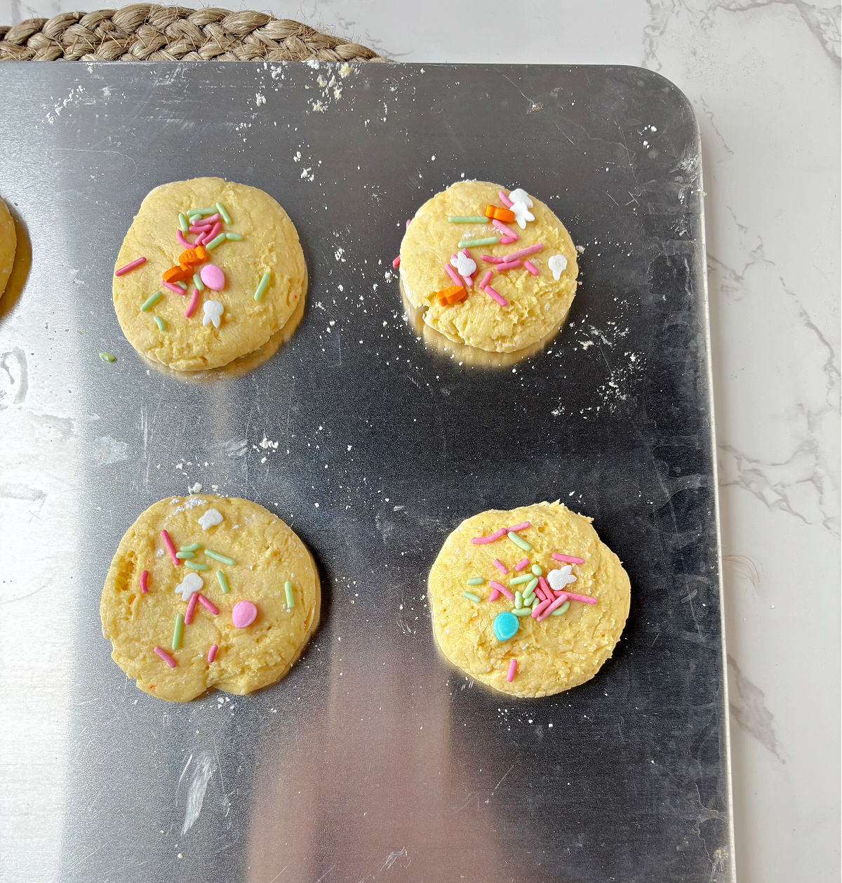Easter cookies ready to be baked on a cookie sheet.