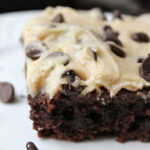 Cookie dough brownie on a white plate with chocolate chips.