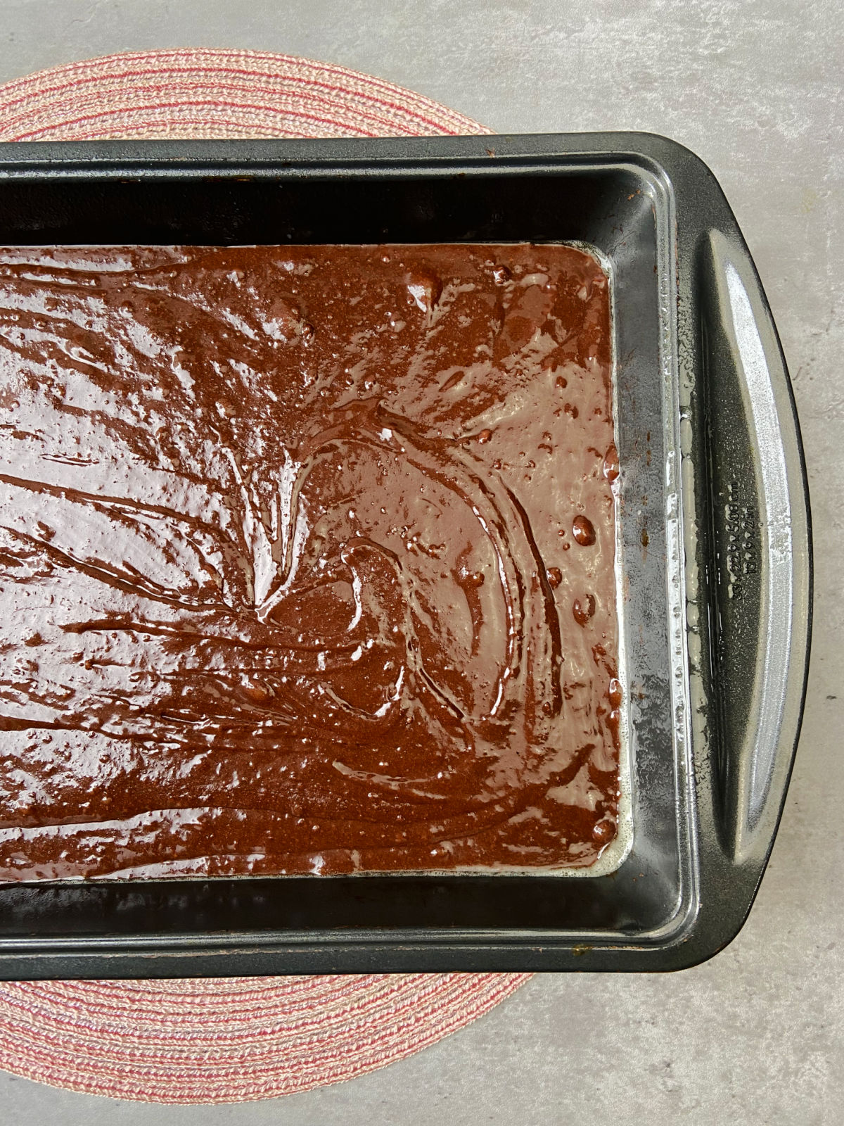 Brownie batter in a cake pan. 