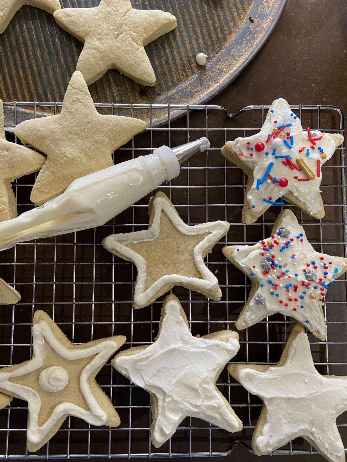 frosting in a piping bag with star cookies. 