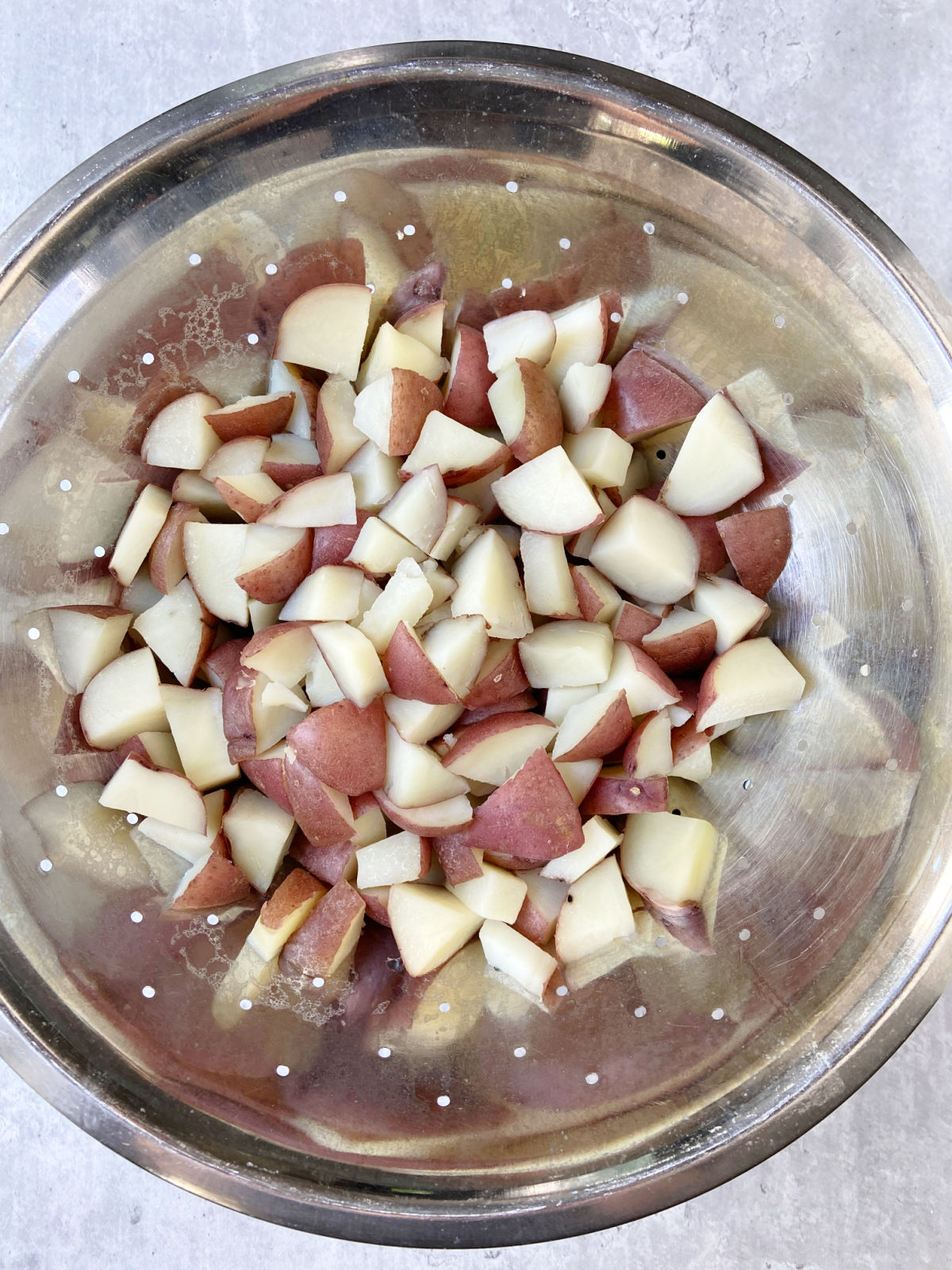 red potatoes in a strainer.