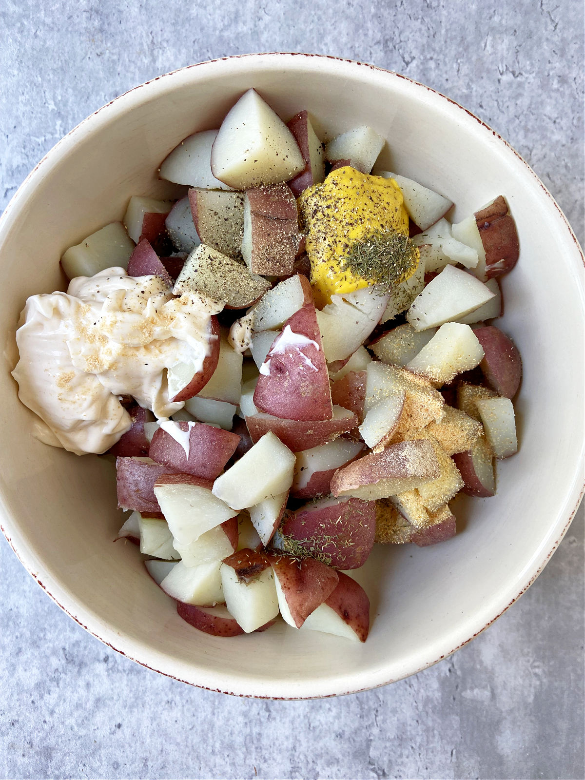 red potatoes in a cream bowl with ingredients. 