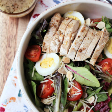grilled chicken salad with a salad dressing on the side.