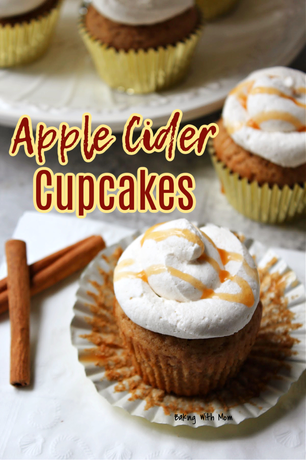 apple cider cupcakes on a cupcake liner with cinnamon nearby. 