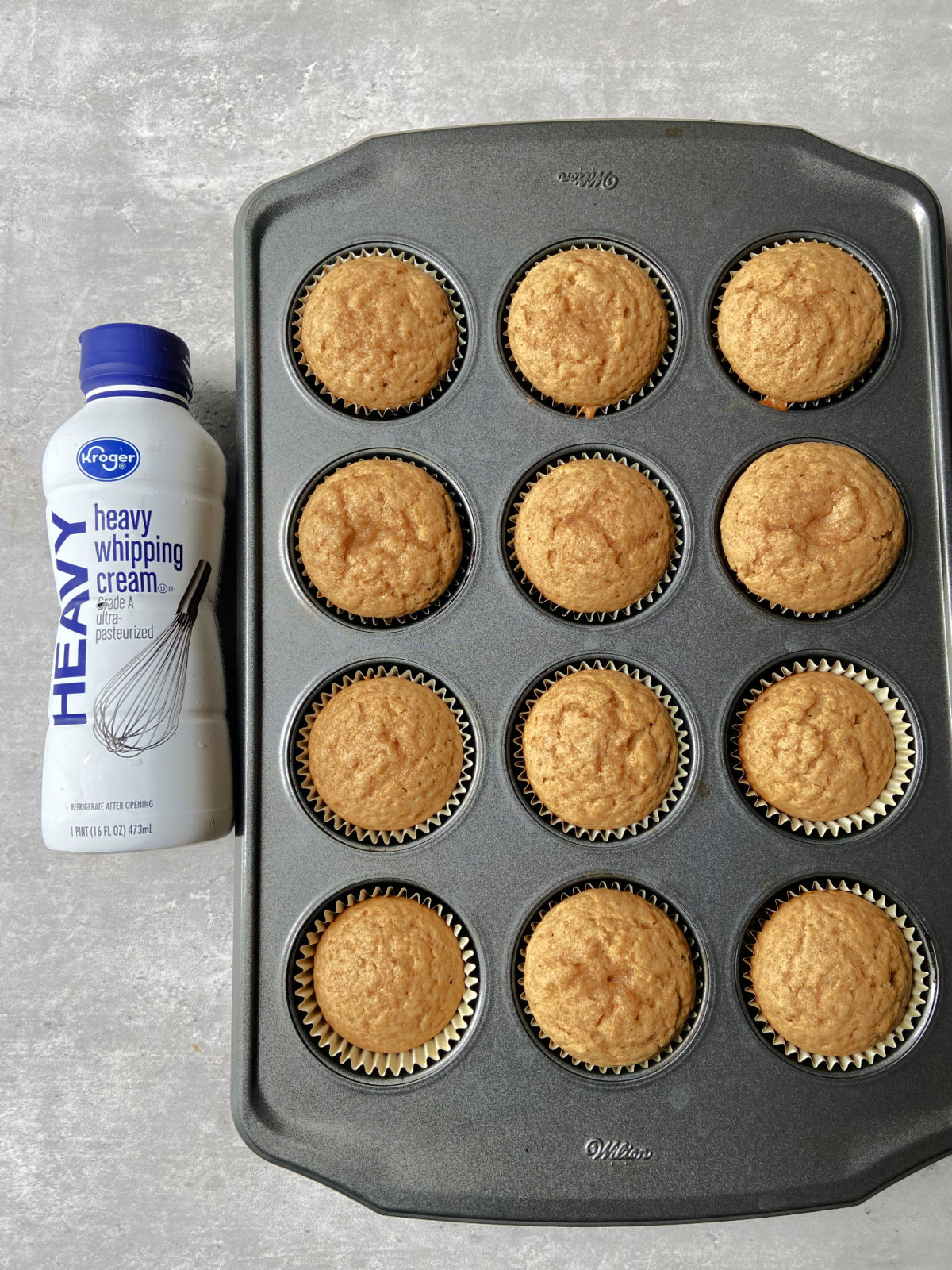 whipping cream next to cupcakes. 