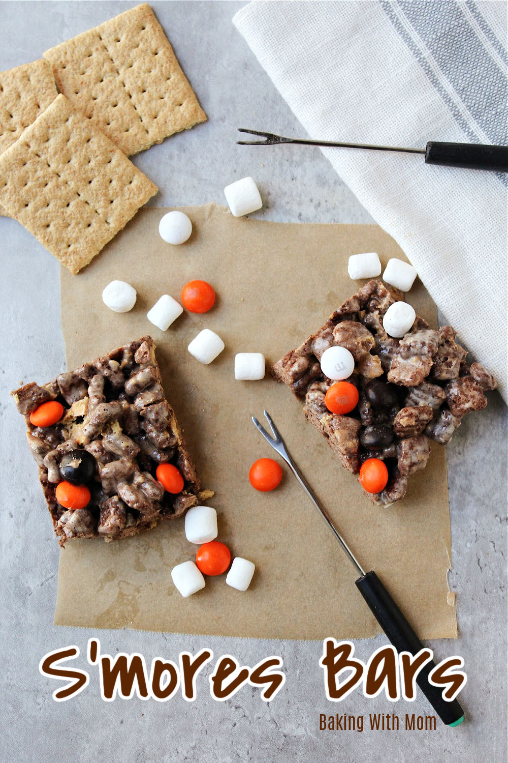 S'mores bars with a towel besides and graham crackers. 