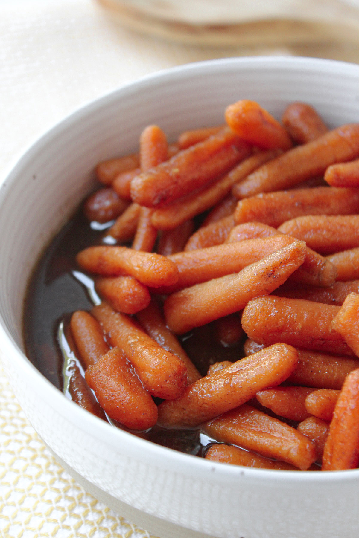 Crock pot glazed carrots in a white bowl. 