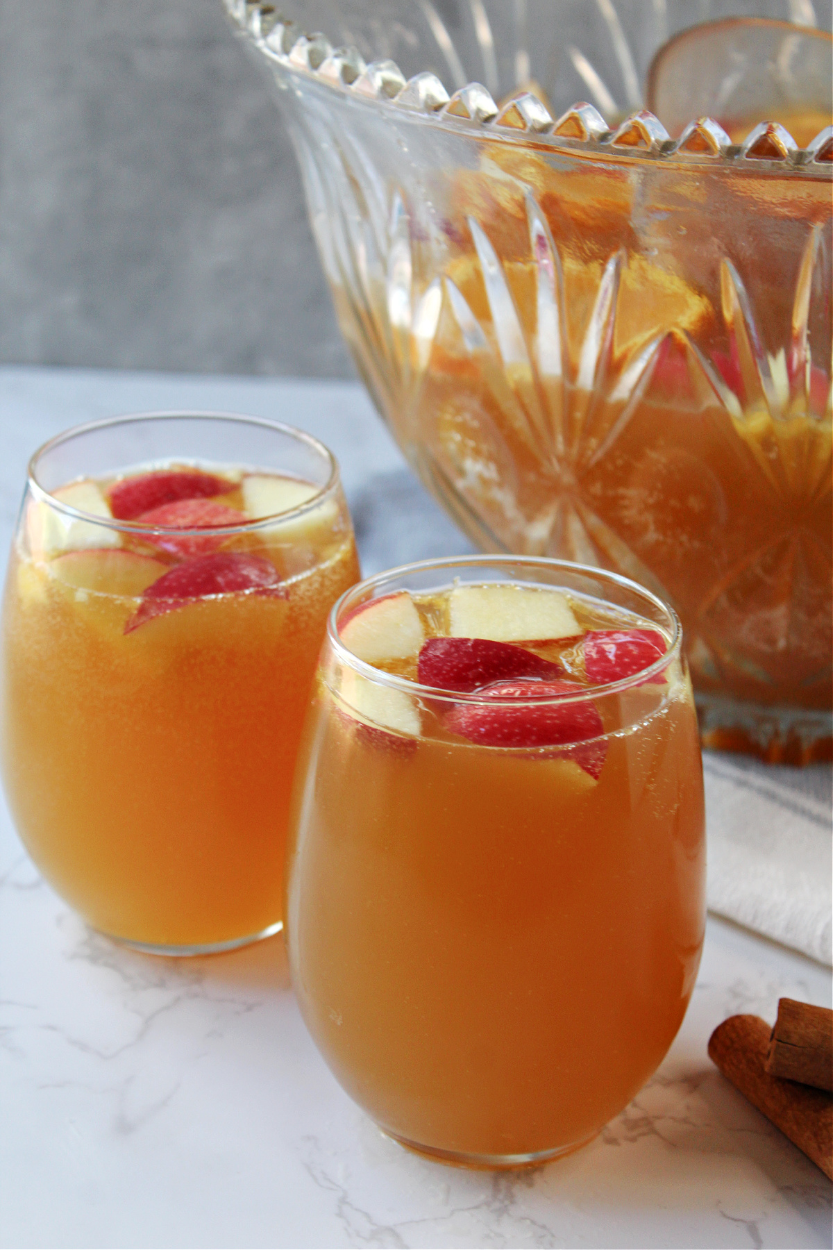 apple cider punch with apple pieces and a punch bowl. 