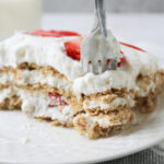 strawberry icebox cake on a white plate with a fork.