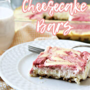 strawberry swirled cheesecake bars on a white plate with a fork.
