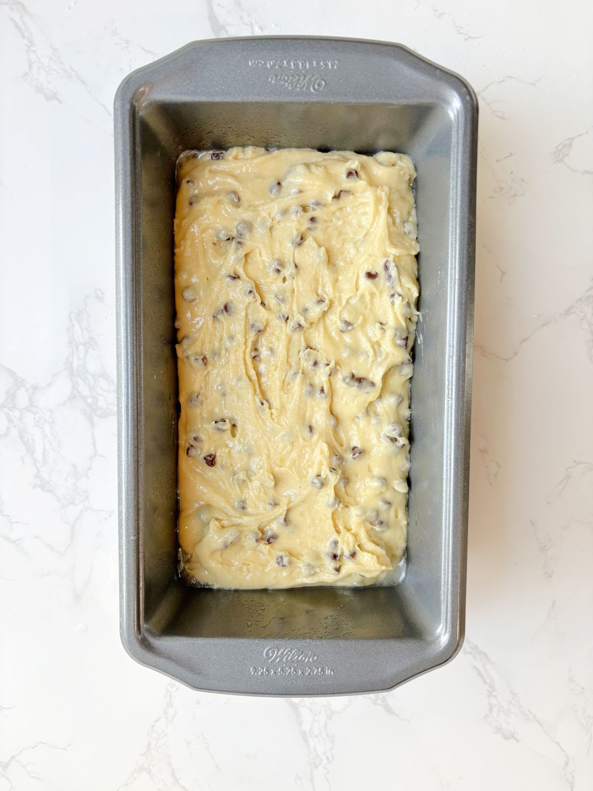 uncooked chocolate chip bread in a loaf pan. 