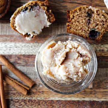 cinnamon honey butter in a clear bowl with muffins behind.