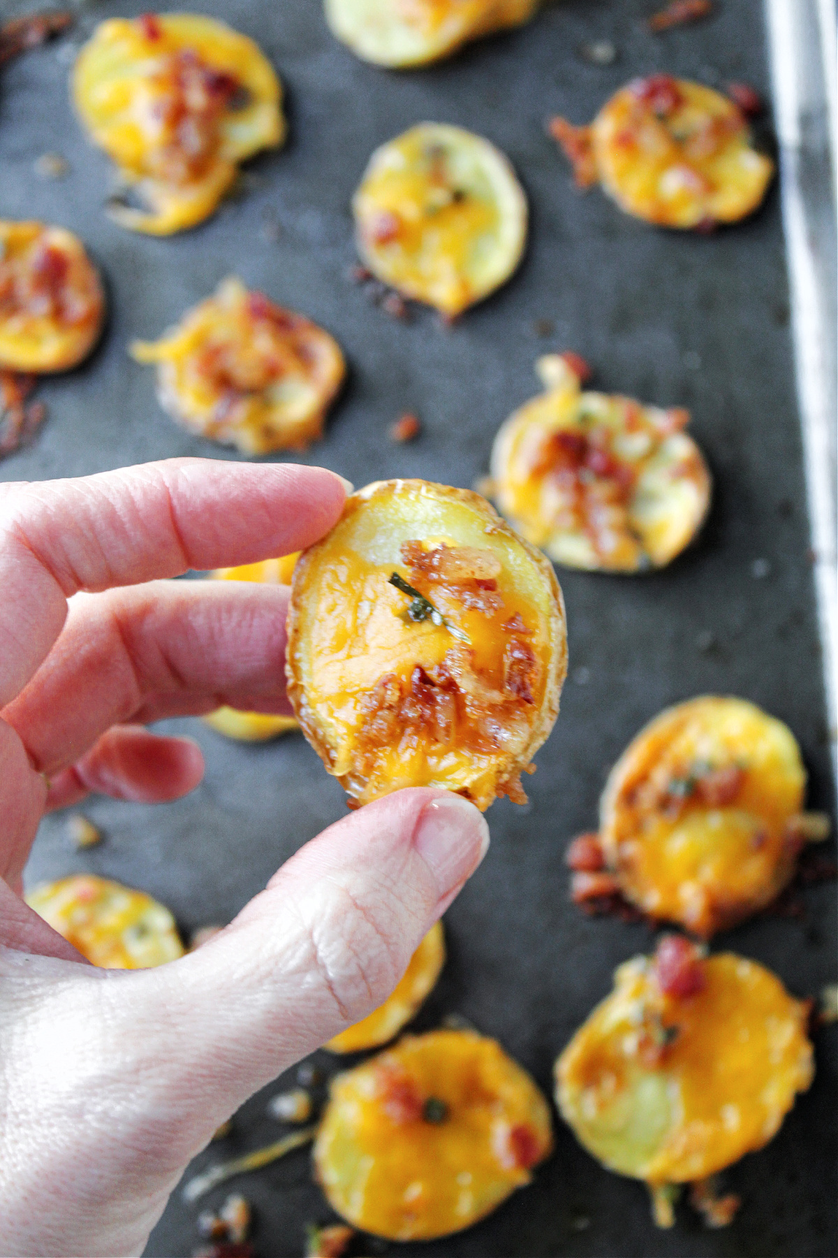 baked potato slices being held by a hand.