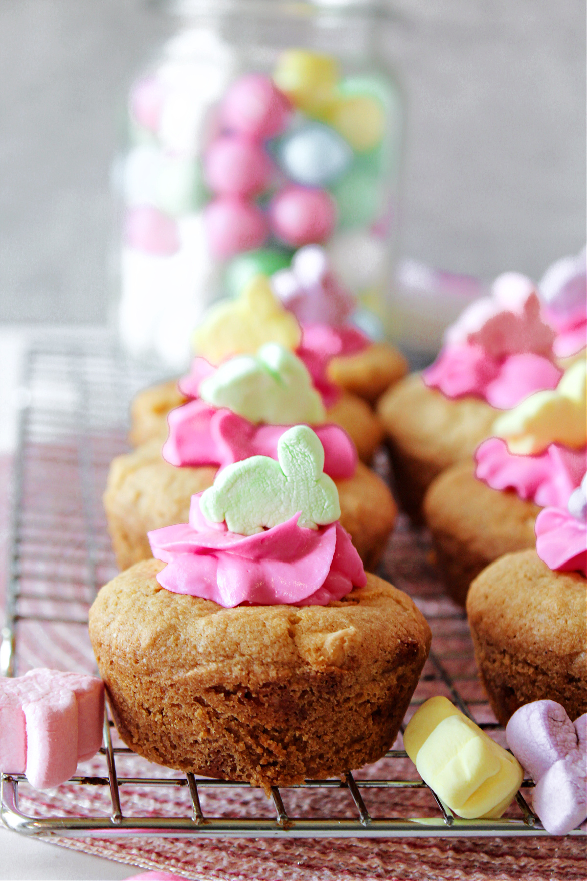 Easter cookie cups with bunny marshmallows on a cooling rack.