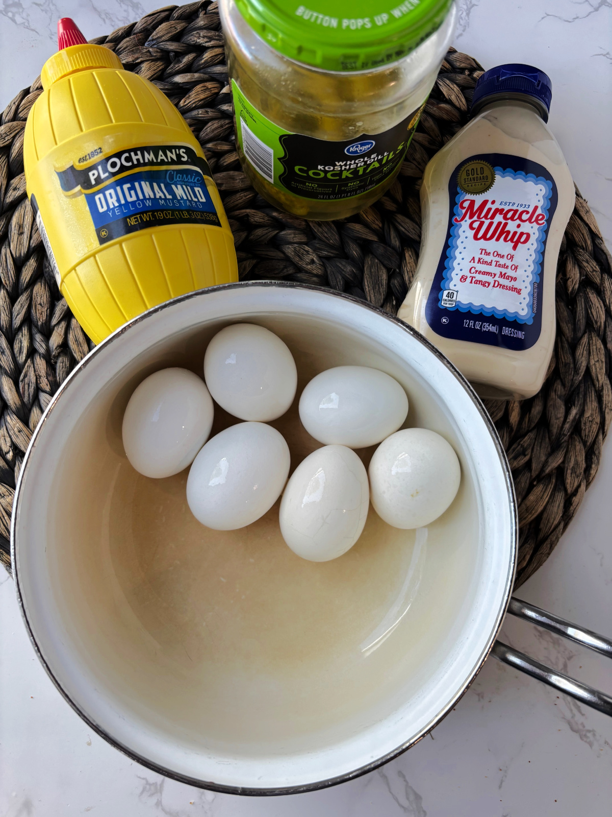 eggs in a pot, mustard, mayonnaise and dill pickles. 