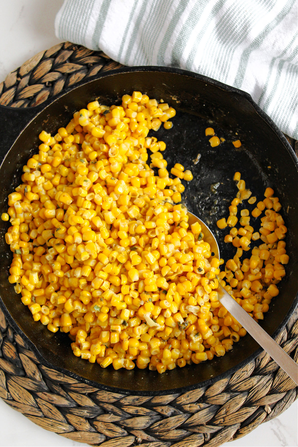 fried corn in a skillet with a spoon. 