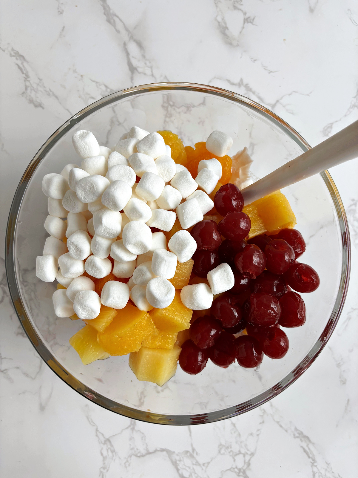 marshmallows and cherries and mandarins in a bowl. 