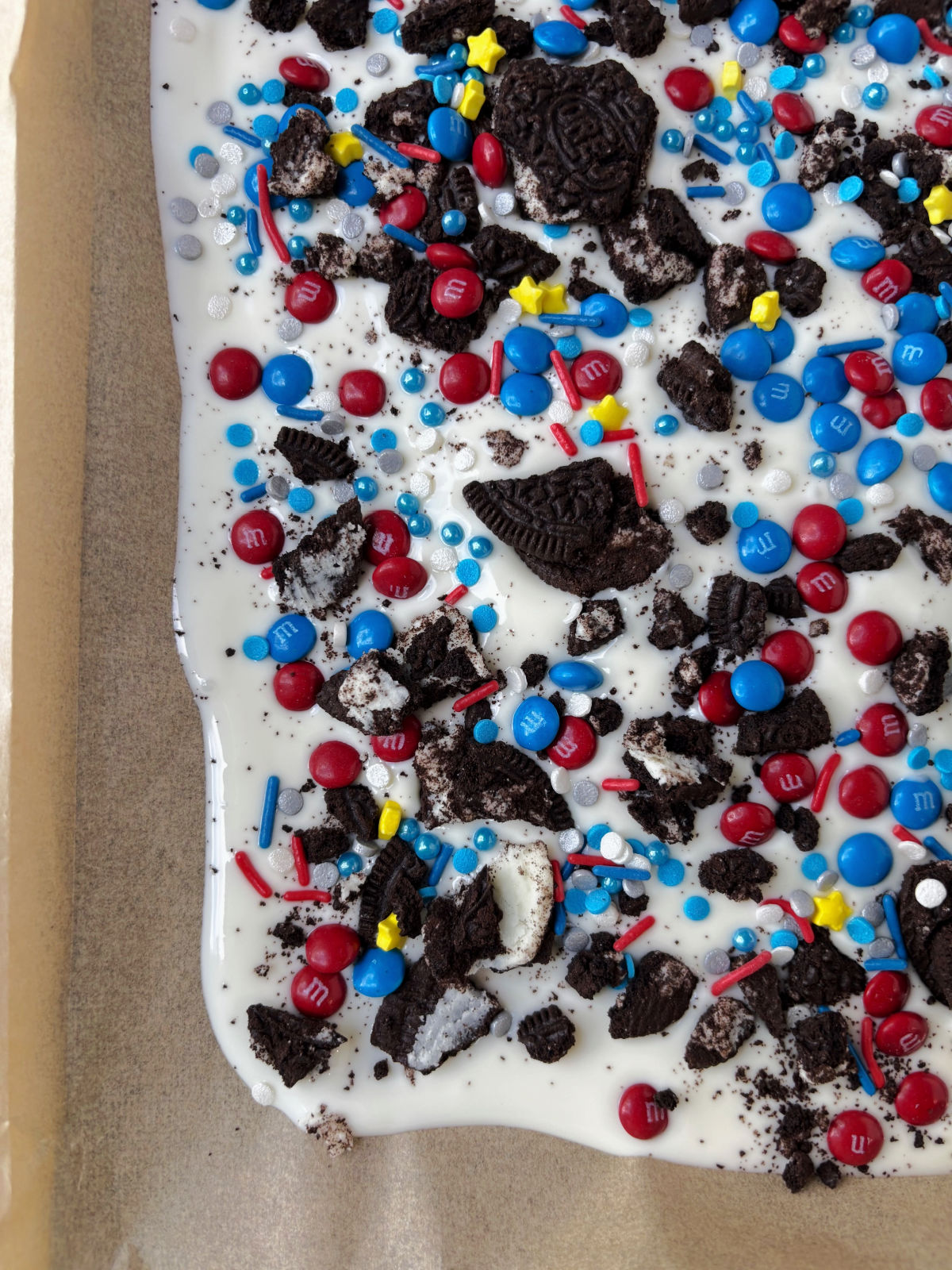 melted almond bark with candy, sprinkles and Oreos on top.