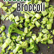 Roasted Broccoli on a baking sheet with a spatula behind.