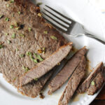 steak on a white plate with a fork.