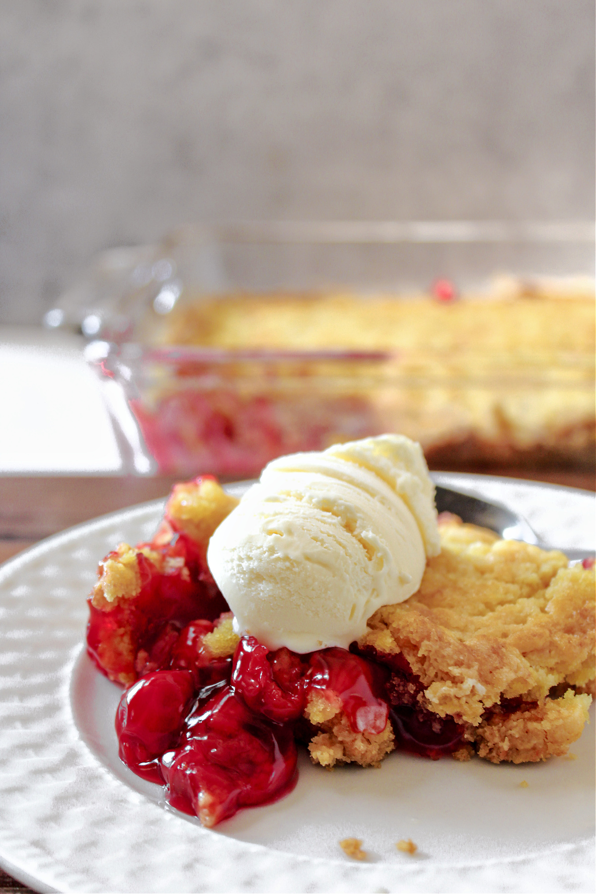 cherry dump cake with a scoop of ice cream on top.