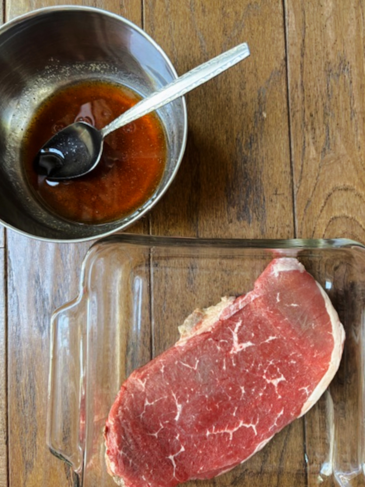 steak in a pan with marinade besides.