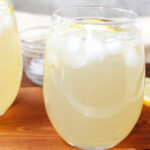 sparkling lemonade in glasses with ice cubes and and lemons.
