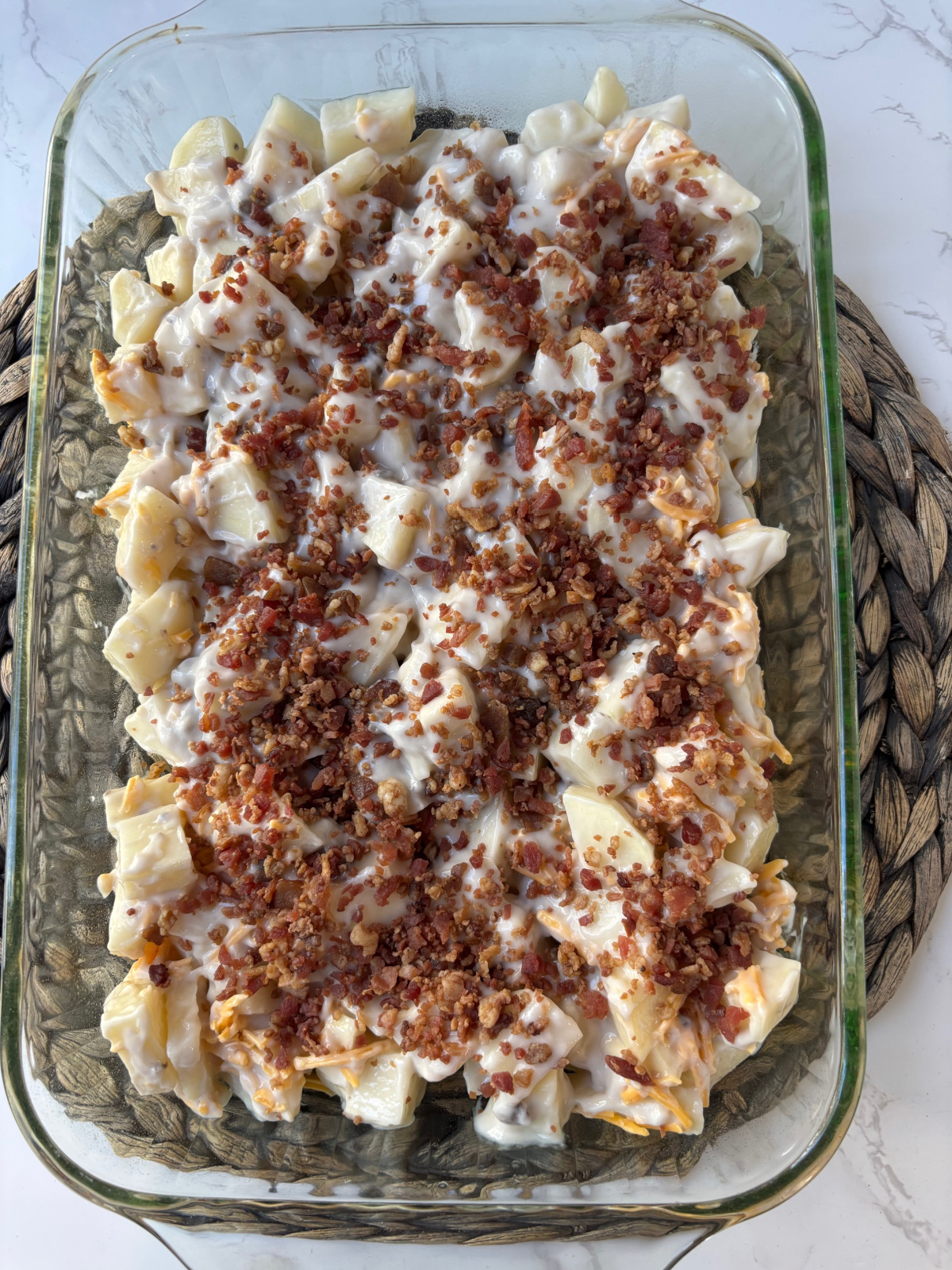 cut potatoes with bacon in a casserole dish.