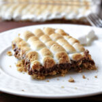 layers of chocolate and marshmallow in a dessert bar on a white plate.