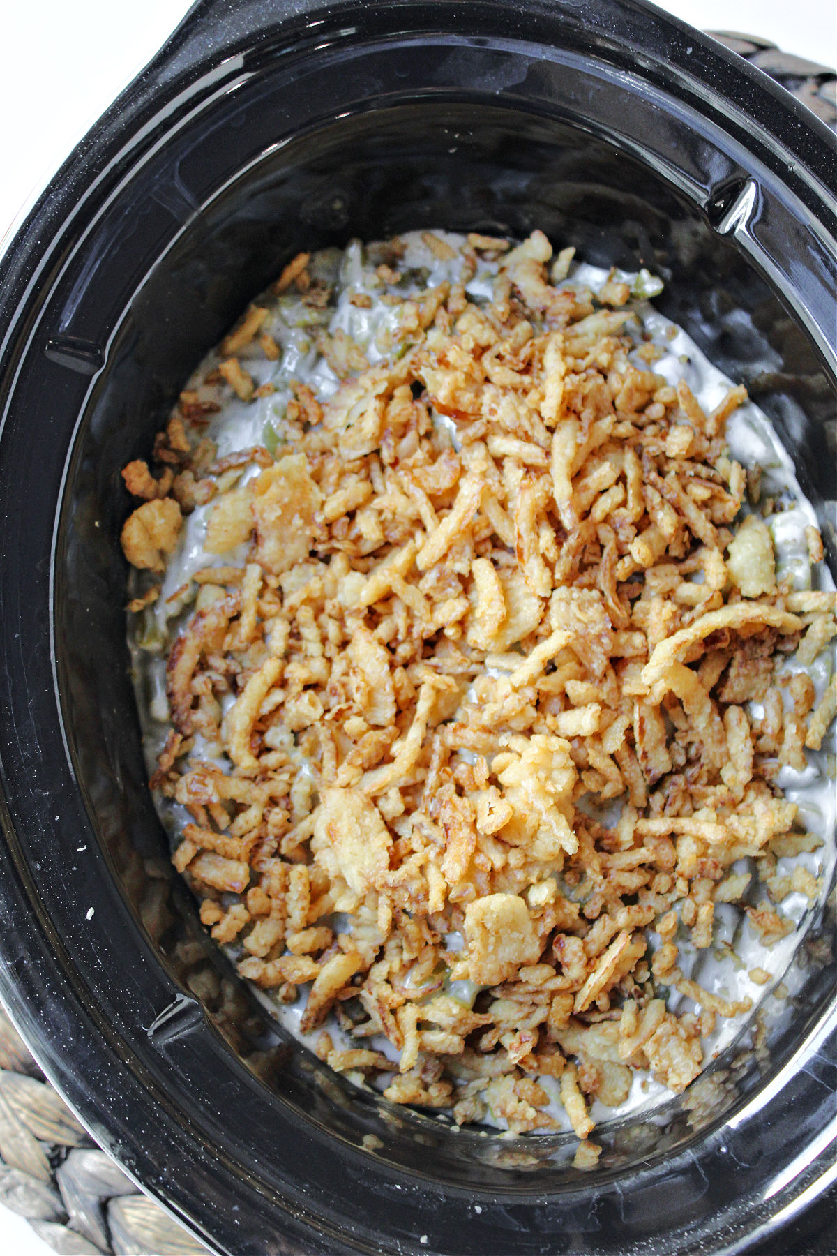 crock pot green bean casserole in a black crock pot. 