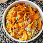 Fritos Corn Salad on a placemat in a cream bowl.