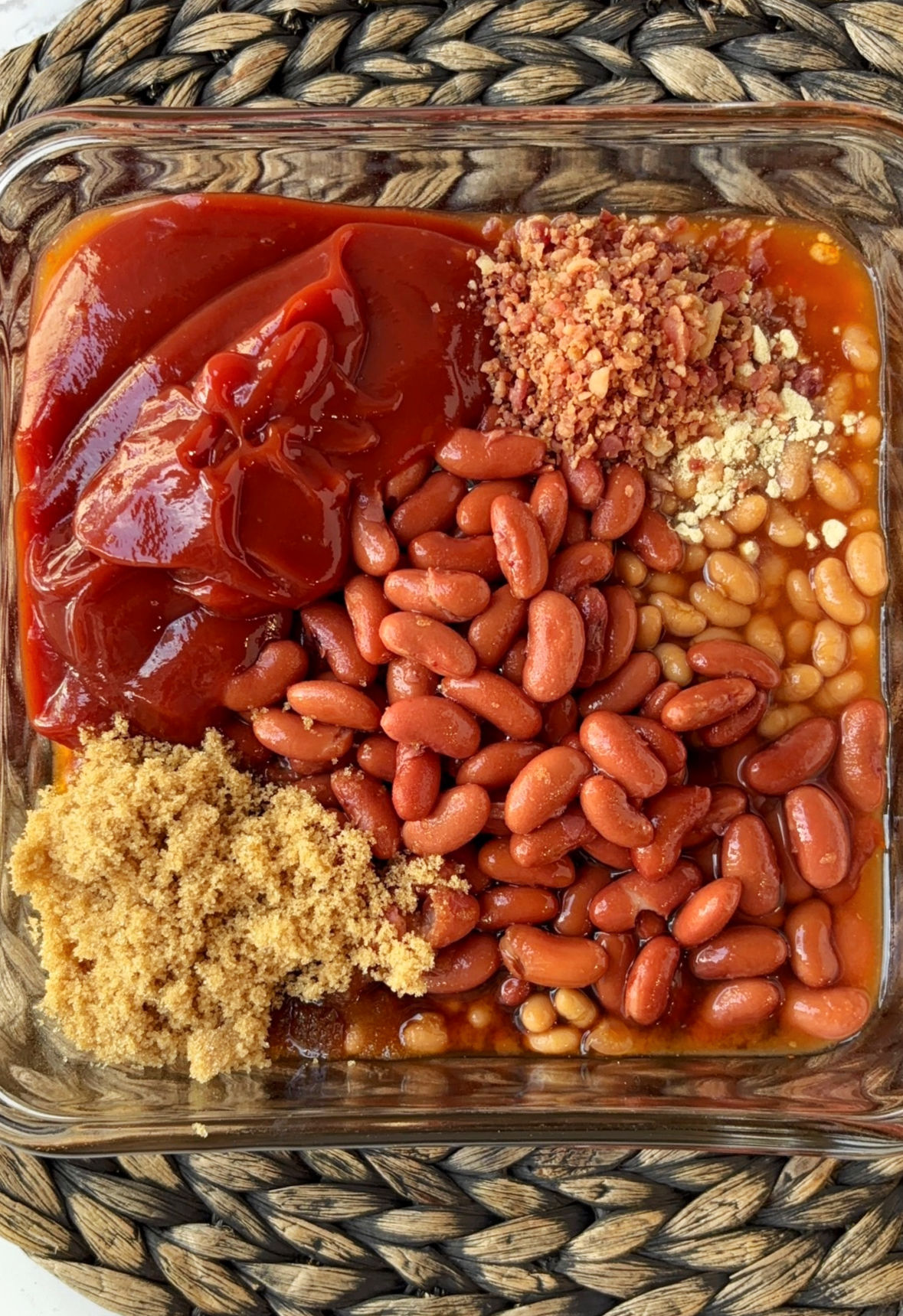 baked beans with kidney beans and other spices in a baking dish.