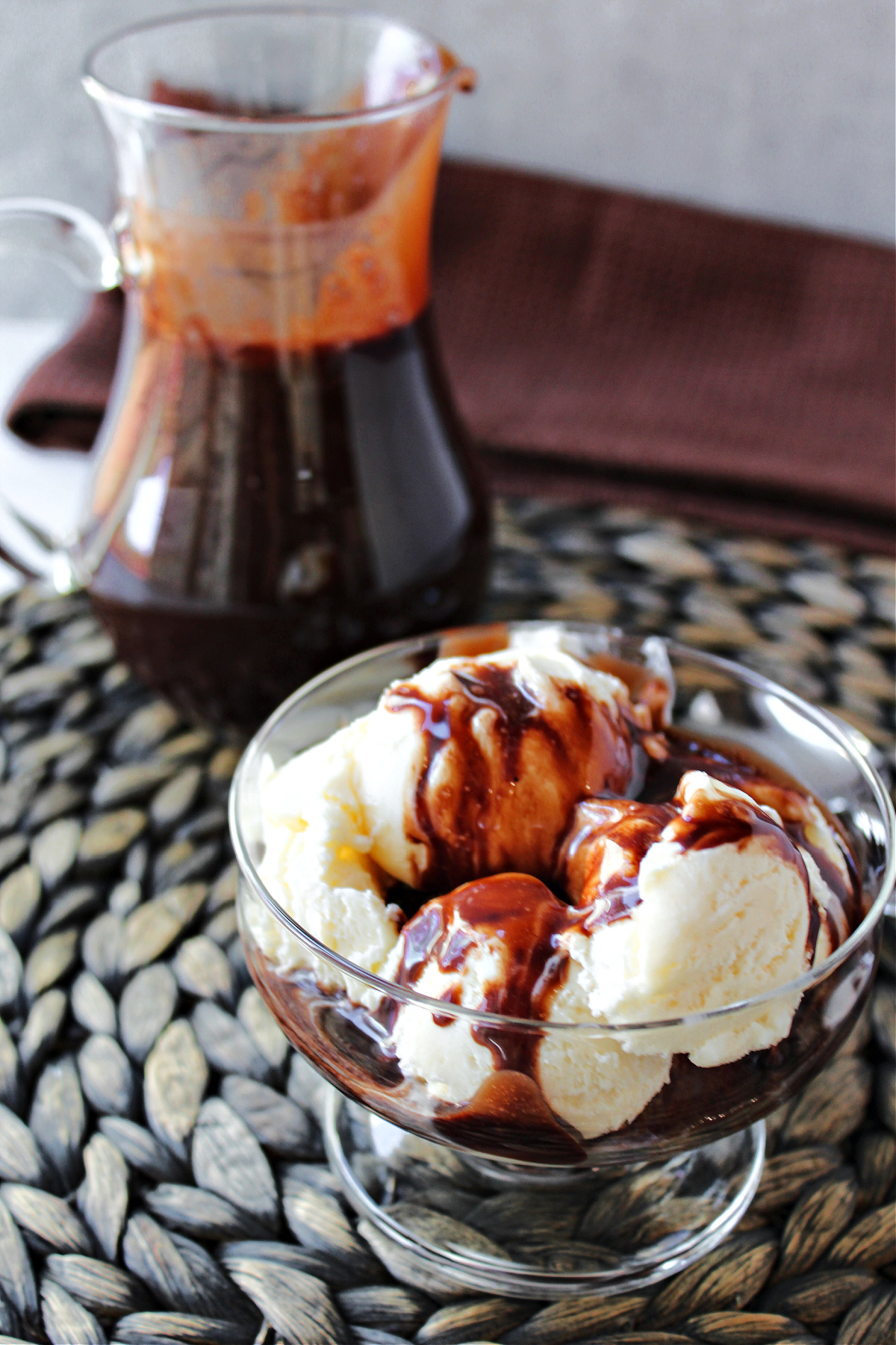 homemade chocolate sauce in a clear bowl with ice cream. 