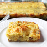 egg bake on a white plate with a fork nearby.