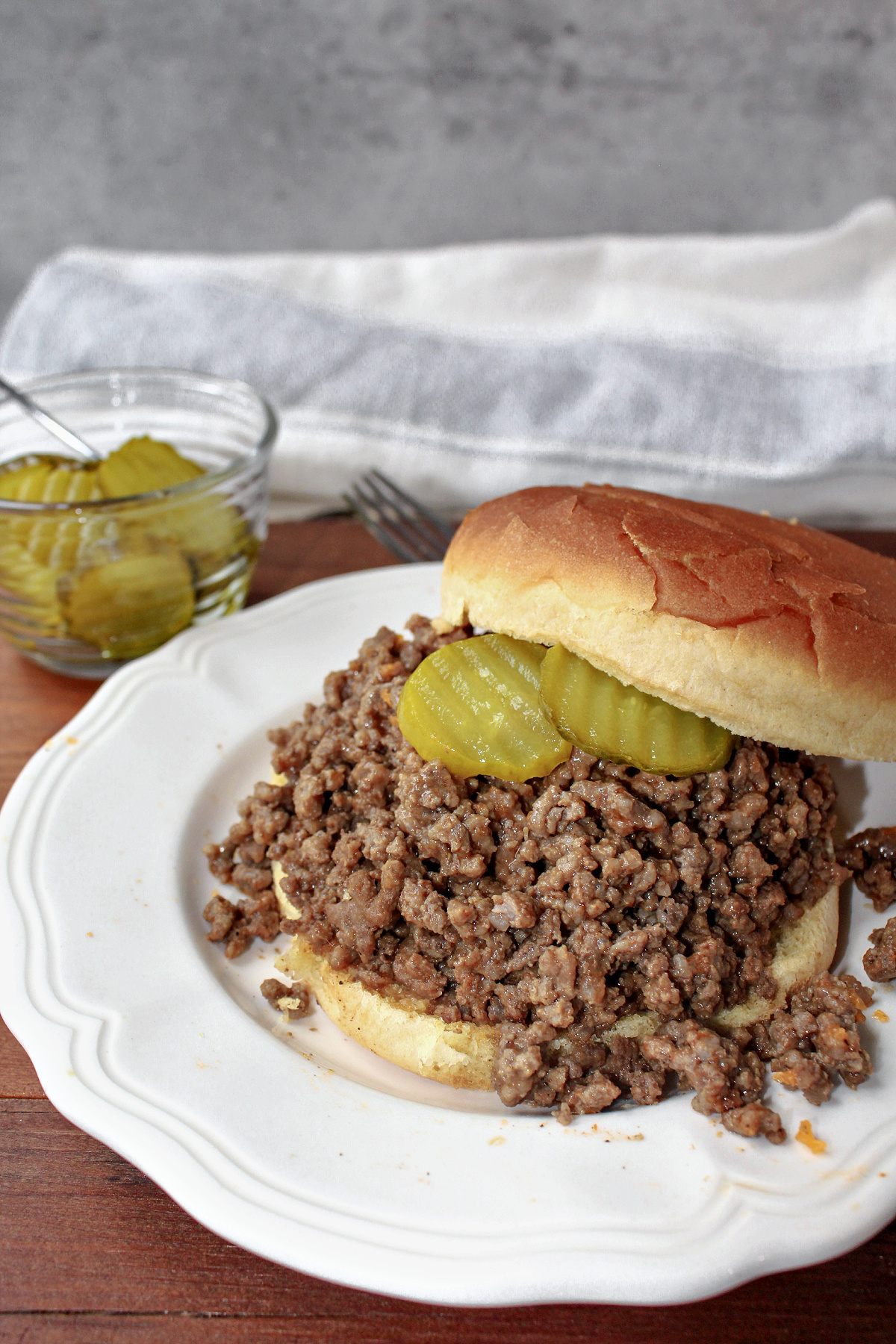 Cheeseburger BBQ on a bun on a white plate.