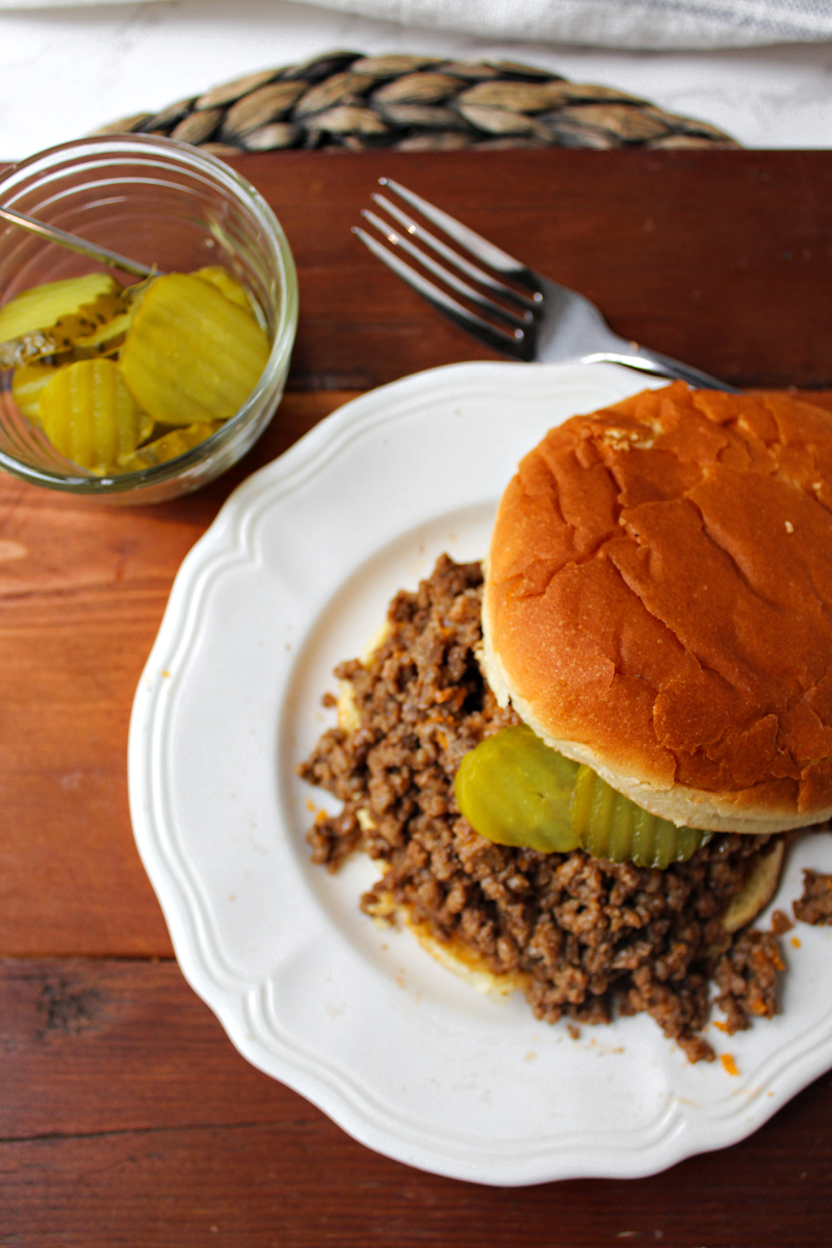cheeseburger bbq on a white plate with a fork.