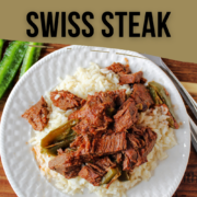 Swiss Steak on a white plate with green peppers.