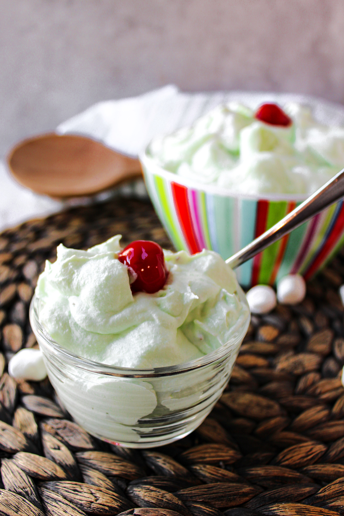 watergate salad in a clear bowl with a cherry on top. 