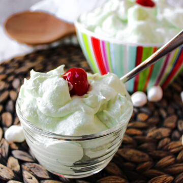 watergate salad in a clear bowl with a spoon.