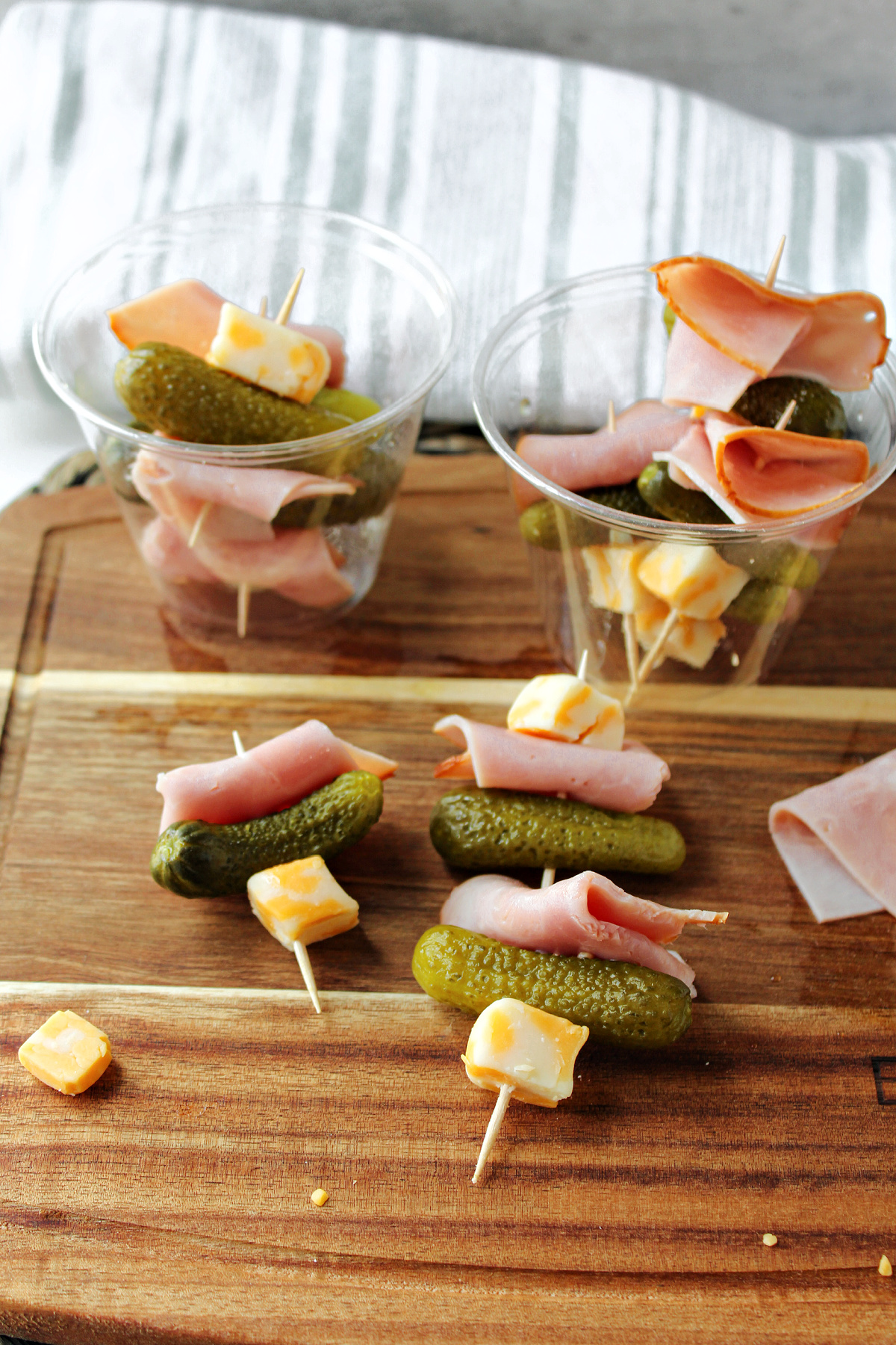 ham cheese and pickle appetizers on a brown tray. 
