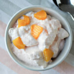 peach lemonade fluff in a white bowl on a colored towel.