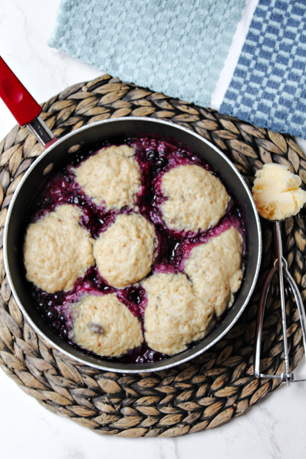 blueberry dumplings in a red pan. 