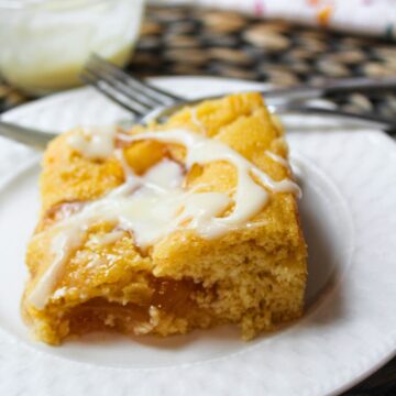 apple pie cake on a white plate with a fork behind.