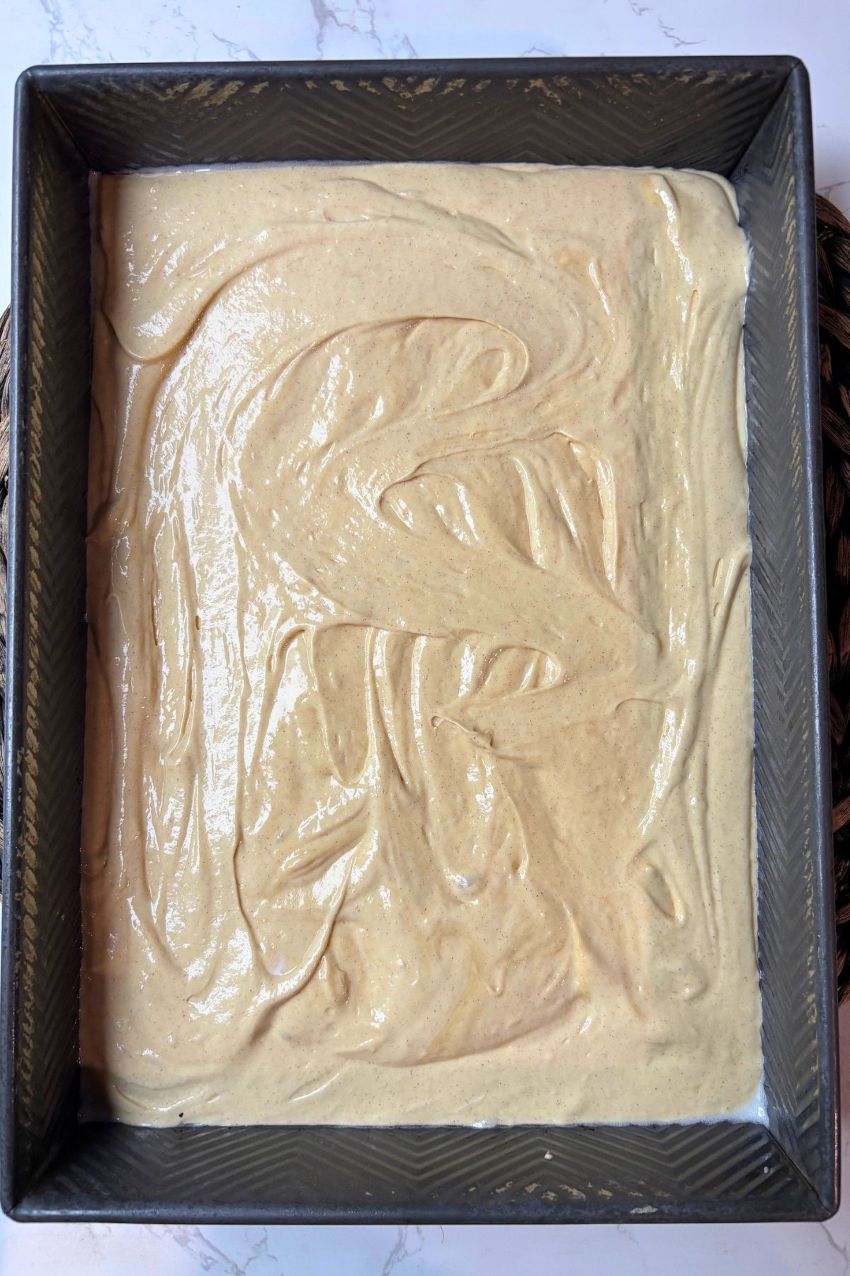 apple pie cake batter in a cake pan.