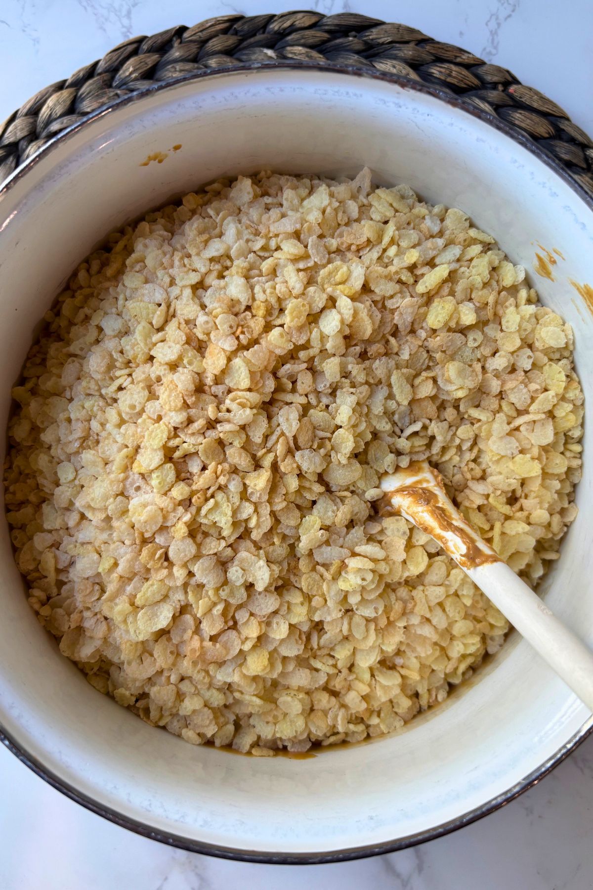 Rice Krispie's in a pot with a spoon.